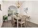 Sunlit dining room with wood floors, a modern chandelier, and a view to the screened-in patio at 248 Breezy Oaks Ct, Davenport, FL 33896