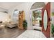 Bright foyer with tile flooring, a red front door, and an arch window that leads to a comfortable living area at 248 Breezy Oaks Ct, Davenport, FL 33896