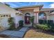 Inviting home exterior with a red front door and manicured landscaping at 248 Breezy Oaks Ct, Davenport, FL 33896
