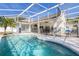 Backyard with a sparkling pool, a screened enclosure, and a large patio area at 248 Breezy Oaks Ct, Davenport, FL 33896