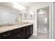 Well-lit bathroom featuring double sinks, granite counters, and shower at 281 Jetty Way, Davenport, FL 33897