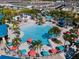 Aerial view of the community pool with colorful umbrellas and plenty of seating at 281 Jetty Way, Davenport, FL 33897