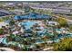 Aerial view of the community pool area, complete with lazy river, water slides, and ample seating at 281 Jetty Way, Davenport, FL 33897