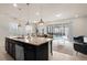 Modern kitchen island with granite countertops, stainless steel appliances, and open living space at 281 Jetty Way, Davenport, FL 33897