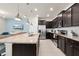 Well-equipped kitchen with dark cabinetry, granite countertops, and seamless access to the living area at 281 Jetty Way, Davenport, FL 33897