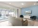 Stylish living room with blue accent wall, modern furniture, and a view of the outdoor pool area at 281 Jetty Way, Davenport, FL 33897
