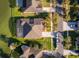 Aerial view of a home with a screened-in patio by the lake, a well-maintained lawn, and a three-car driveway at 2864 Lafayette Trace Dr, St Cloud, FL 34772