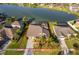 An aerial view of a well-manicured property featuring a waterfront backyard, screened-in patio, and mature landscaping at 2864 Lafayette Trace Dr, St Cloud, FL 34772