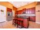 Modern kitchen boasts a central island, stainless steel fridge, and dark wood cabinets at 2864 Lafayette Trace Dr, St Cloud, FL 34772