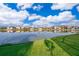 Picturesque lakefront view showcasing a tranquil lake with a lush green lawn and a row of houses reflecting in the water at 2864 Lafayette Trace Dr, St Cloud, FL 34772