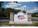 Welcome to The Colonies. Entrance sign surrounded by green lawn and tall trees on a sunny day at 3060 George Mason Ave # 12 D, Winter Park, FL 32792