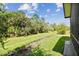 Backyard view with green grass and lush trees at 309 Vestrella Dr, Poinciana, FL 34759