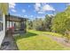 Backyard view with enclosed patio, green grass and lush trees at 309 Vestrella Dr, Poinciana, FL 34759