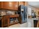 Modern kitchen with dark stainless steel fridge, ample wood cabinets, and convenient pull-out shelving for easy storage at 309 Vestrella Dr, Poinciana, FL 34759