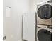 Convenient laundry area with stackable washer and dryer and adjacent white refrigerator, offering practical home amenities at 309 Vestrella Dr, Poinciana, FL 34759