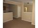 Neutral open-concept living space with beige walls, carpet and partial view of the kitchen area at 3712 Castle Pines Ln # 4126, Orlando, FL 32839