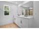 Bright bathroom featuring white cabinets, black hardware, and double sinks at 3725 Deer Ridge Dr, Mount Dora, FL 32757