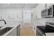 Open kitchen with white cabinets, stainless appliances, quartz counters, and wood-look flooring at 3725 Deer Ridge Dr, Mount Dora, FL 32757