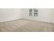 A carpeted bedroom with large window provides plenty of natural light at 3741 Deer Ridge Dr, Mount Dora, FL 32757