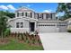 Two-story home featuring a three car garage, gray paint, black shutters and a well maintained lawn at 3741 Deer Ridge Dr, Mount Dora, FL 32757