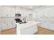 Modern kitchen featuring a center island, stainless steel appliances, sleek white cabinets, and bright wood flooring at 3741 Deer Ridge Dr, Mount Dora, FL 32757