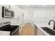 Modern kitchen featuring stainless steel appliances, sleek white cabinets, subway tile backsplash, and wood flooring at 3741 Deer Ridge Dr, Mount Dora, FL 32757