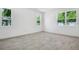 Bright bedroom with wood-look tile flooring, white walls, and views through three windows at 3749 Deer Ridge Dr, Mount Dora, FL 32757