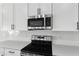 Close-up of the kitchen with stainless steel microwave and oven, and sleek black hardware at 3749 Deer Ridge Dr, Mount Dora, FL 32757