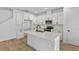Bright kitchen with white cabinets, stainless steel appliances, a center island, and wood-look flooring at 3757 Deer Ridge Dr, Mount Dora, FL 32757