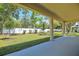 Covered patio with view of backyard featuring a white fence and green lawn with young trees at 3757 Deer Ridge Dr, Mount Dora, FL 32757
