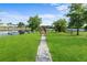 Scenic backyard with a paver pathway leading to a private dock on a tranquil lake, offering a serene outdoor experience at 4217 Park Lake St, Orlando, FL 32803