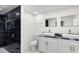 Modern bathroom features double sinks with granite countertops, gold hardware and a sleek black marble shower at 4217 Park Lake St, Orlando, FL 32803