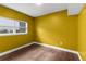 Bright bedroom with striking yellow walls, wood flooring, and ample natural light at 4217 Park Lake St, Orlando, FL 32803