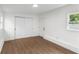 Bright bedroom featuring wood-look flooring, neutral walls, and closet and backyard views at 4217 Park Lake St, Orlando, FL 32803