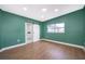 This bedroom features wood floors, an adjacent bathroom, and a large window at 4217 Park Lake St, Orlando, FL 32803