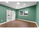 Bedroom with wood-look flooring, green walls, and a modern barn door leading to the ensuite bathroom at 4217 Park Lake St, Orlando, FL 32803