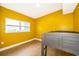 This bedroom features wood floors, a large window, and bright yellow walls at 4217 Park Lake St, Orlando, FL 32803