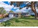 Charming single-story home with a well-maintained lawn, a light-grey exterior, and a driveway leading to an attached garage at 4217 Park Lake St, Orlando, FL 32803