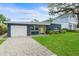 Charming single-story home with a blue exterior, stone accents, a yellow door, and a neatly paved driveway at 4217 Park Lake St, Orlando, FL 32803