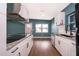 Modern kitchen featuring white cabinets, granite countertops, stainless steel appliances, and hardwood flooring at 4217 Park Lake St, Orlando, FL 32803