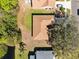 Aerial view of a well maintained roof, large shady tree, and backyard near the lake at 4222 Gold Rush Ln, St Cloud, FL 34772