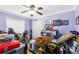 Cluttered bedroom with lilac walls, packed boxes, and household items on a wood floor at 4222 Gold Rush Ln, St Cloud, FL 34772