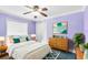 Cozy bedroom with calming lavender walls, plush bedding, and a ceiling fan at 4222 Gold Rush Ln, St Cloud, FL 34772