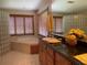 Luxurious bathroom features a soaking tub, granite countertop, and custom wood cabinetry at 4261 Twilight Trl, Kissimmee, FL 34746