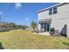 Expansive backyard featuring a well-maintained lawn, patio area with outdoor seating, and a grill at 4544 Teoli Ct, Kissimmee, FL 34746