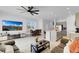 Open floor plan of kitchen, dining, and living room with large television at 4544 Teoli Ct, Kissimmee, FL 34746