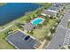 Overhead view of a community pool area featuring a pool, clubhouse, and ample parking in a picturesque setting at 4544 Teoli Ct, Kissimmee, FL 34746