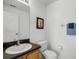 Bathroom featuring a single sink, black countertop, wood cabinets and white toilet at 509 Cadiz Loop, Davenport, FL 33837