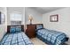 Bedroom featuring two beds with plaid bedding, a window, and tasteful decor at 509 Cadiz Loop, Davenport, FL 33837