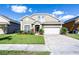 Charming two-story home features a well-manicured lawn and a brick-paved driveway, complete with an attached two-car garage at 509 Cadiz Loop, Davenport, FL 33837